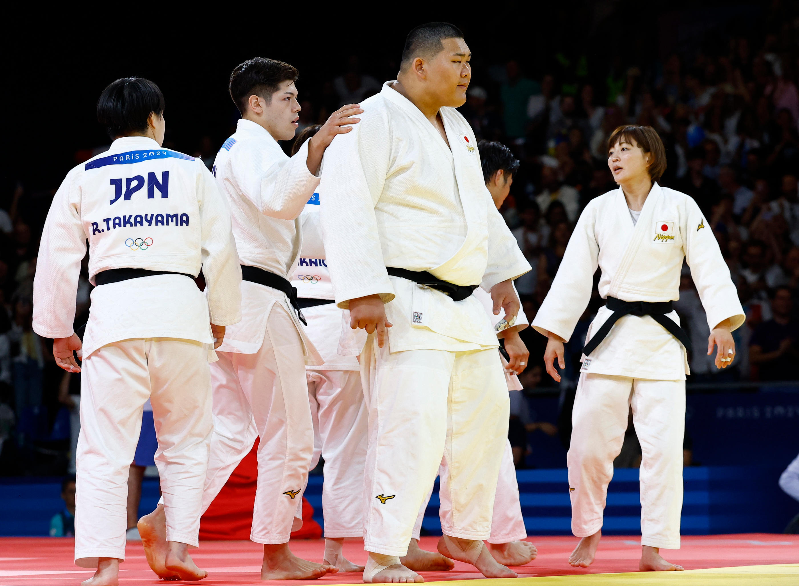 Au centre, Tatsuru Saito est encouragé par ses coéquipiers et coéquipières avant son combat décisif face à Teddy Riner, ce samedi. REUTERS/Kim Kyung-Hoon