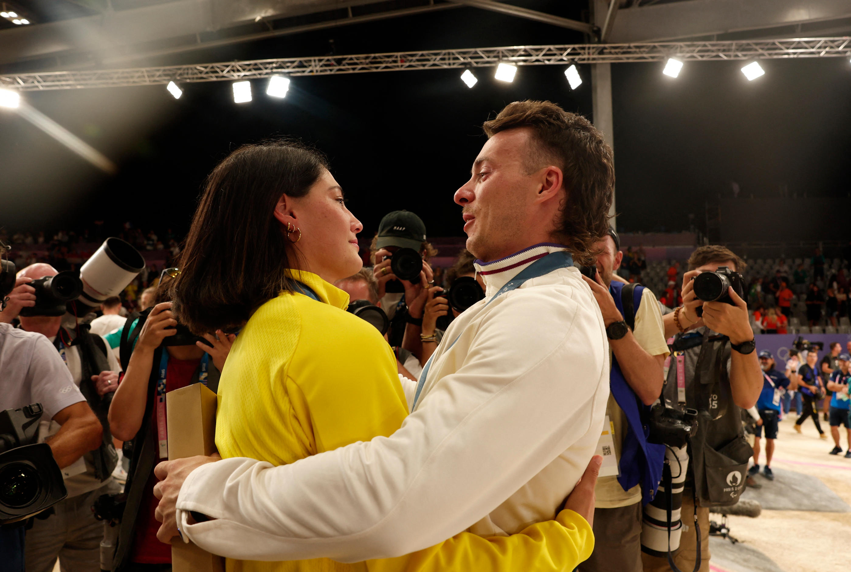 Vélodrome national de Saint-Quentin-en-Yvelines, le 2 août 2024. La médaillée d'or australienne Saya Sakakibara (à gauche) dans les bras de son compagnon français et médaillé de bronze Romain Mahieu (Reuters/ /Gonzalo Fuentes)