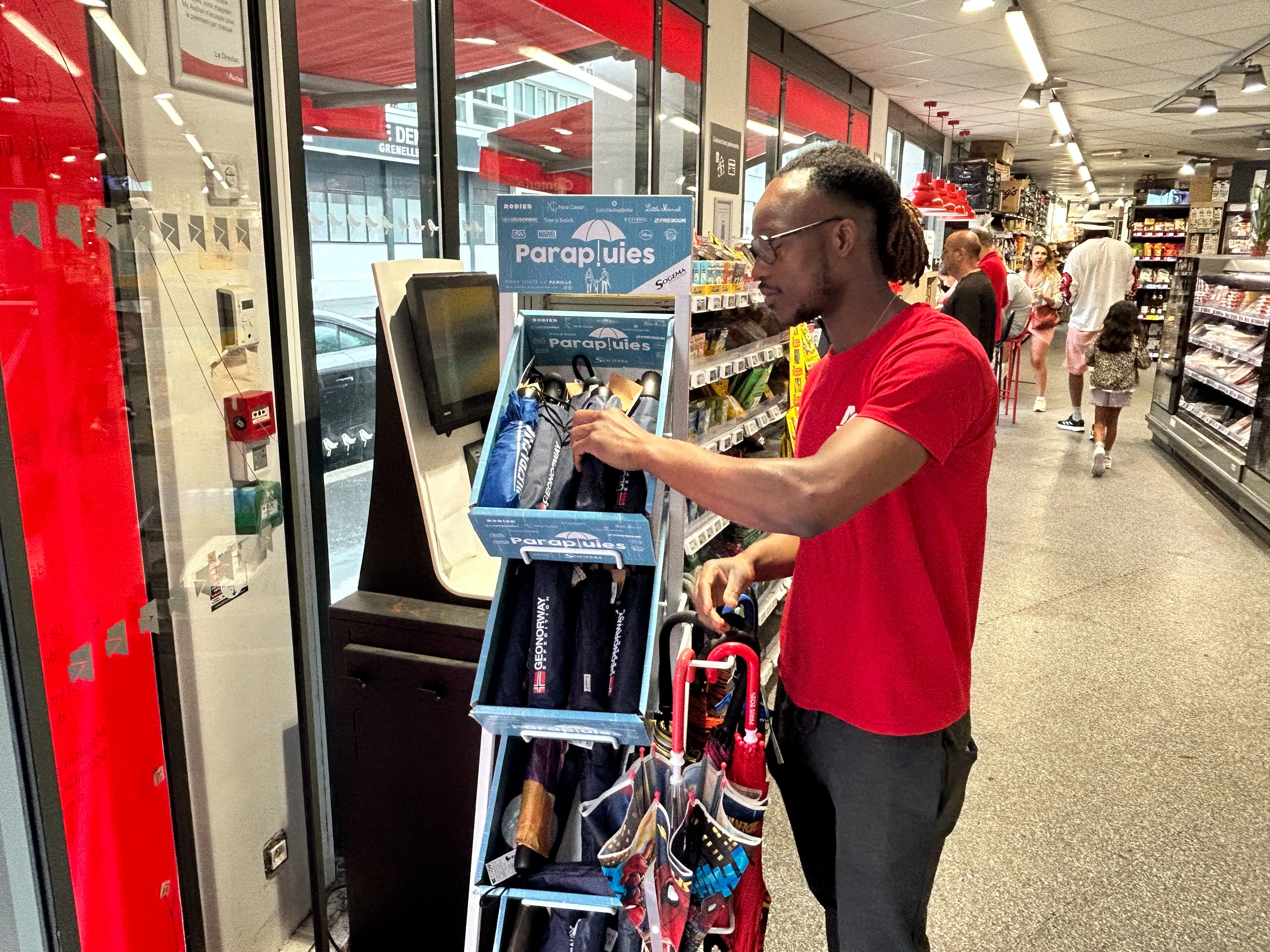 Le magasin où travaille Grégory, 32 ans, a enregistré une vente record de parapluies pour un jour de juillet. LP/Willem Foloppe