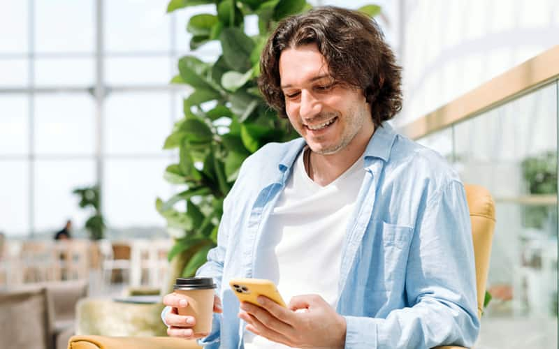 hombre mirando el teléfono y sonriendo