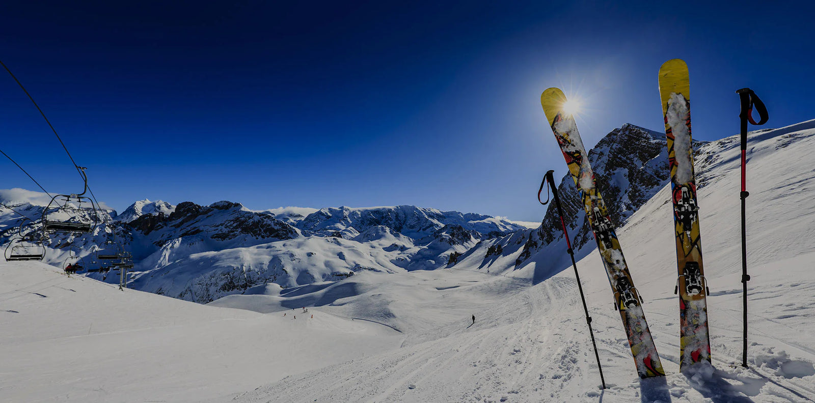 Pair of skis sticking out of the snow on a scenic mountain slope