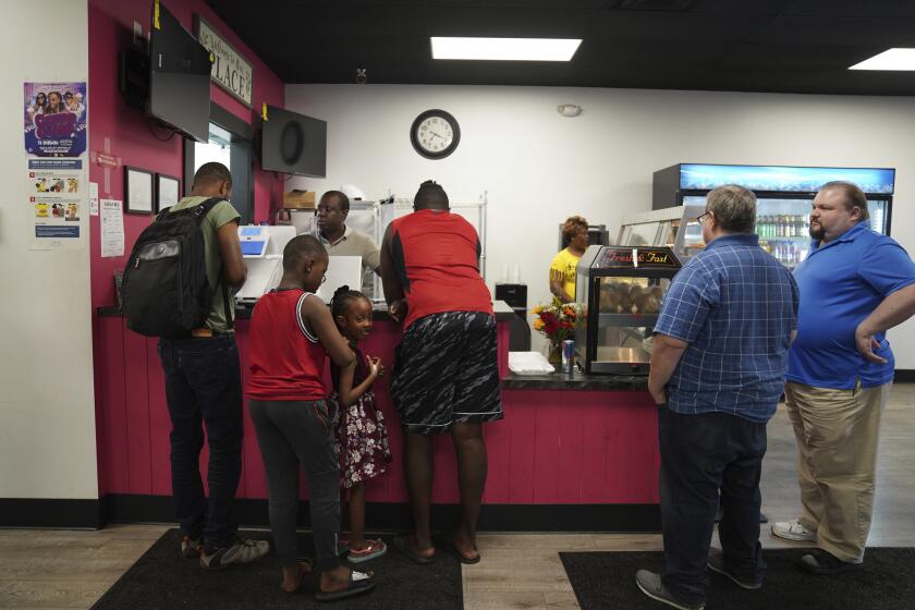 Romane Pierre, del restaurante Rose Goute Creole en Springfield, Ohio, atiende a clientes el lunes 16 de septiembre de 2024. (AP Foto/Jessie Wardarski)