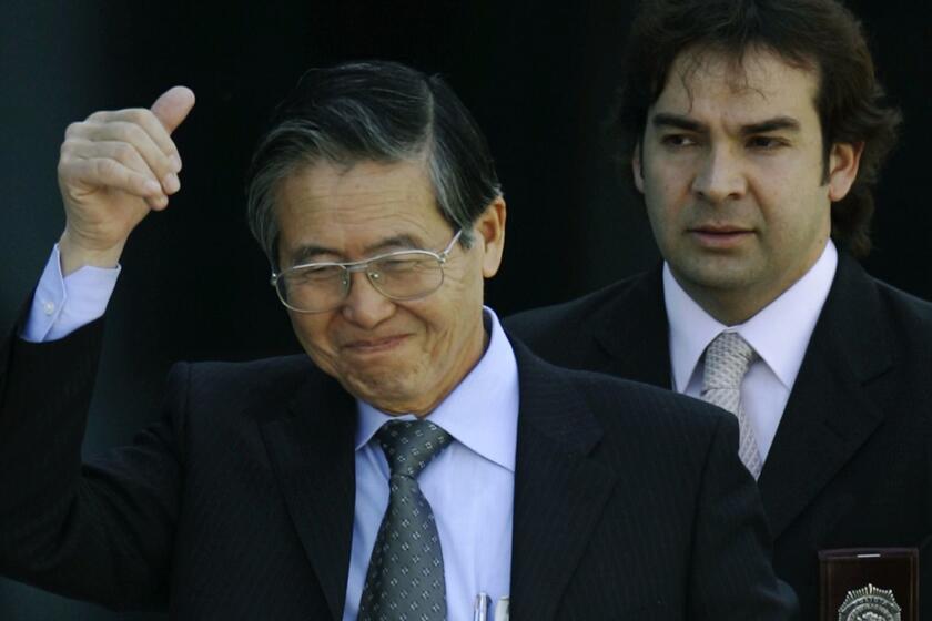 Flanked by Chilean investigative police, former Peruvian President Alberto Fujimori gives a "thumbsup" sign as he leaves the Chilean investigative police academy in Santiago, Chile, Monday, Nov. 7, 2005. Fujimori was arrested in Chile Monday on charges at home involving corruption and massacres, as he attempted to return to Peru to run for reelection after five years as a protected exile in Japan. (AP Photo/Roberto Candia)