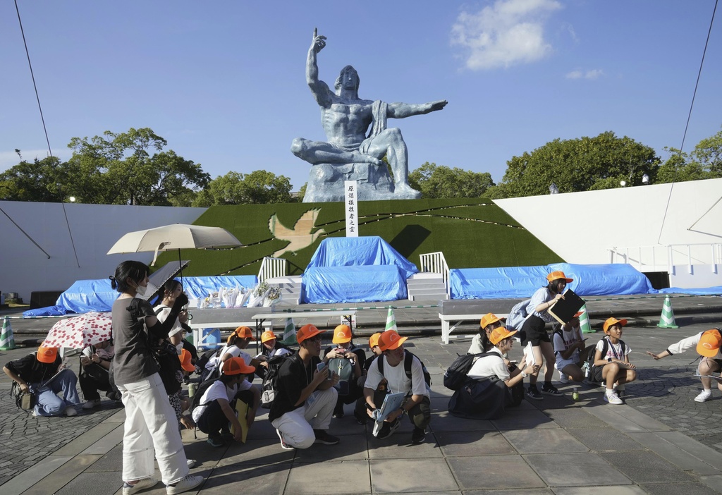 Visitors to the Peace Park crouch.