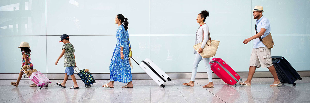 Family walking with suitcases in terminal 5 at Heathrow, London.