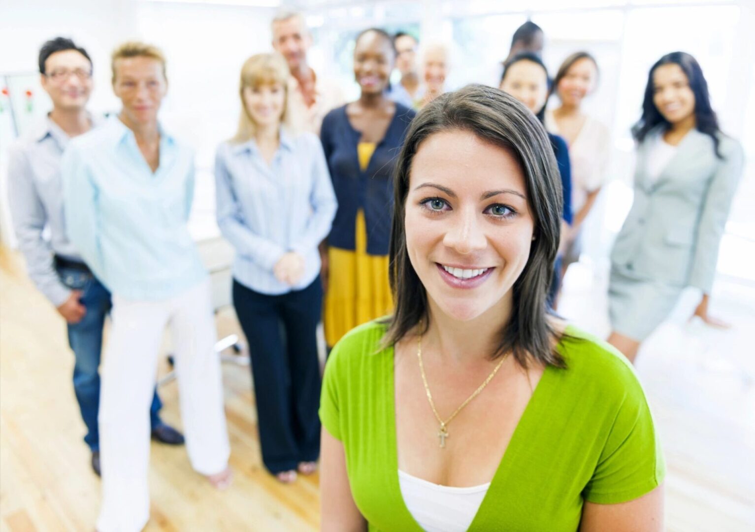 A group of people standing in a room with one woman smiling.