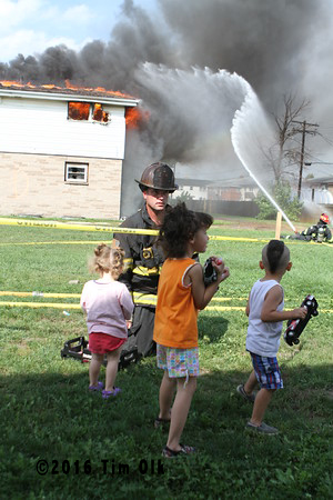 children watch a fire department burn down