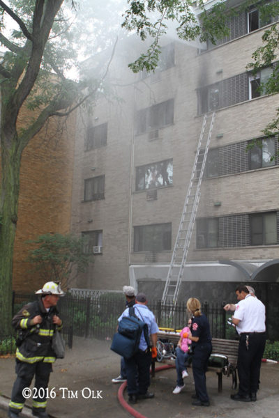 Chicago FD paramedics treat an elderly fire victim at the scene of a fire