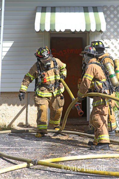 firefighters pulling hose