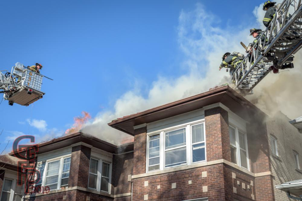 Firefighters vent roof of apartment building on fire