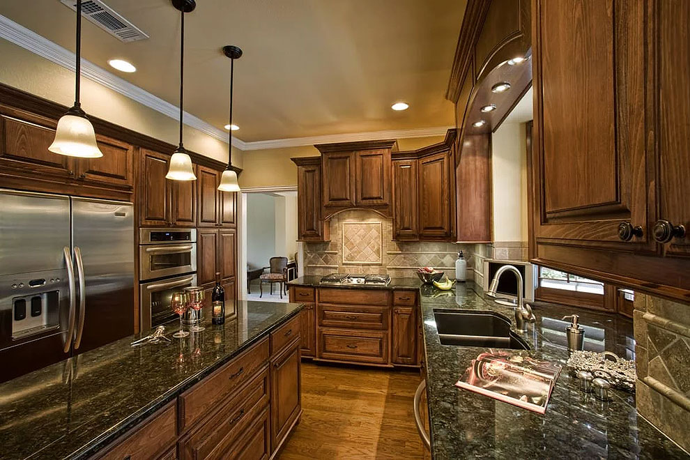 dark brown cabinetry peacock counters travertine tile wood floor light wood cabinets emerald green granite rainforest green granite countertop jade green