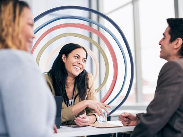 man sitting at employee conference smiling