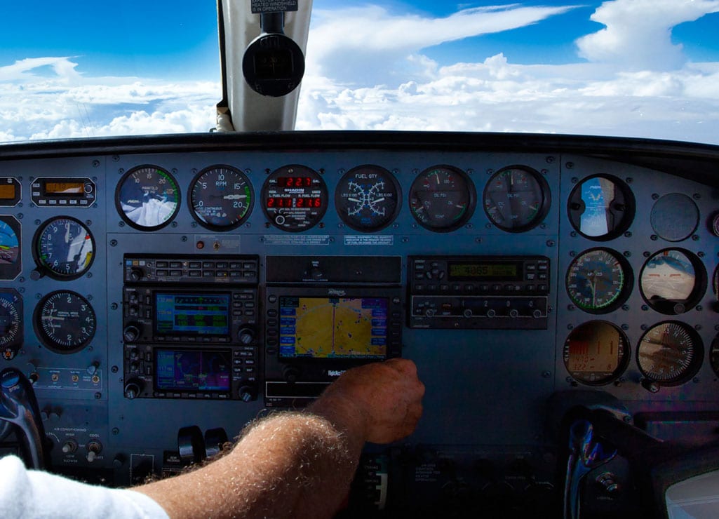 Pilot adjusting GPS on instrument panel of Cessna 421 - FAA Schedules 2017 GPS Interference Testing advisories