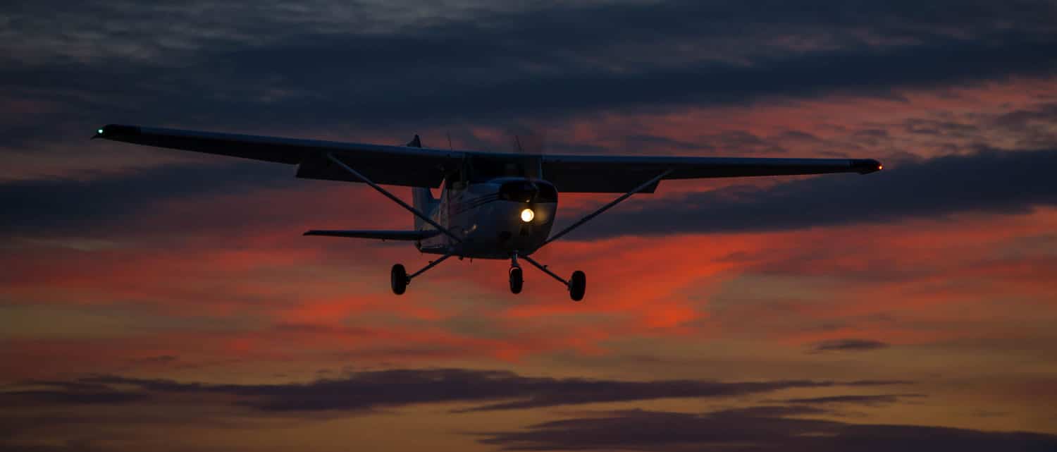 A small Cessna aircraft enjoying some night flying.