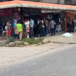 Foto de ciudadanos y policías reunidos ante el asesinato de dos estudiantes en el barrio Las Palmeras del cantón Santa Rosa, de la provincia de El Oro.