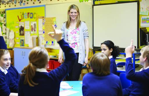 En la imagen se puede ver a una profesora dando clases en una escuela.