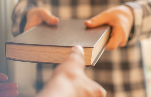 Foto referencial de personas cambiando un libro