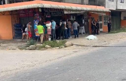 Foto de ciudadanos y policías reunidos ante el asesinato de dos estudiantes en el barrio Las Palmeras del cantón Santa Rosa, de la provincia de El Oro.