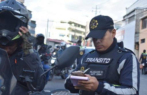 Un agente civil de tránsito emite una multa.