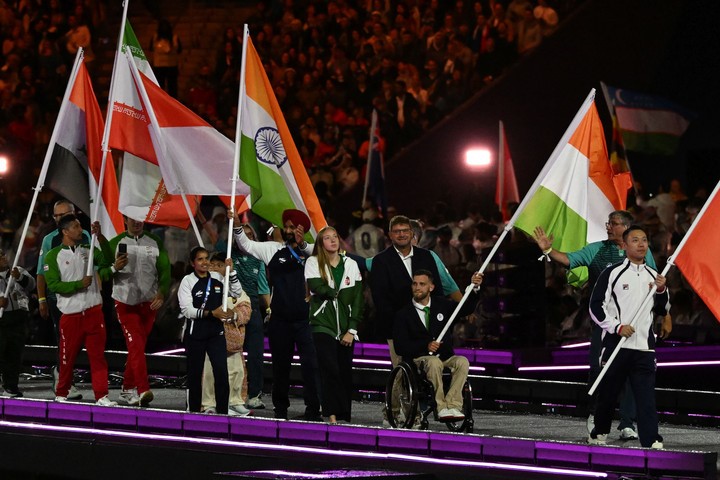 Konkoly Zsófia úszó és Kiss Péter Pál kajakozó (középen) viszi a magyar zászlót a 2024-es párizsi nyári paralimpiai játékok záróünnepségén a Stade de France-ban - fotó: MTI Koszticsák Szilárd