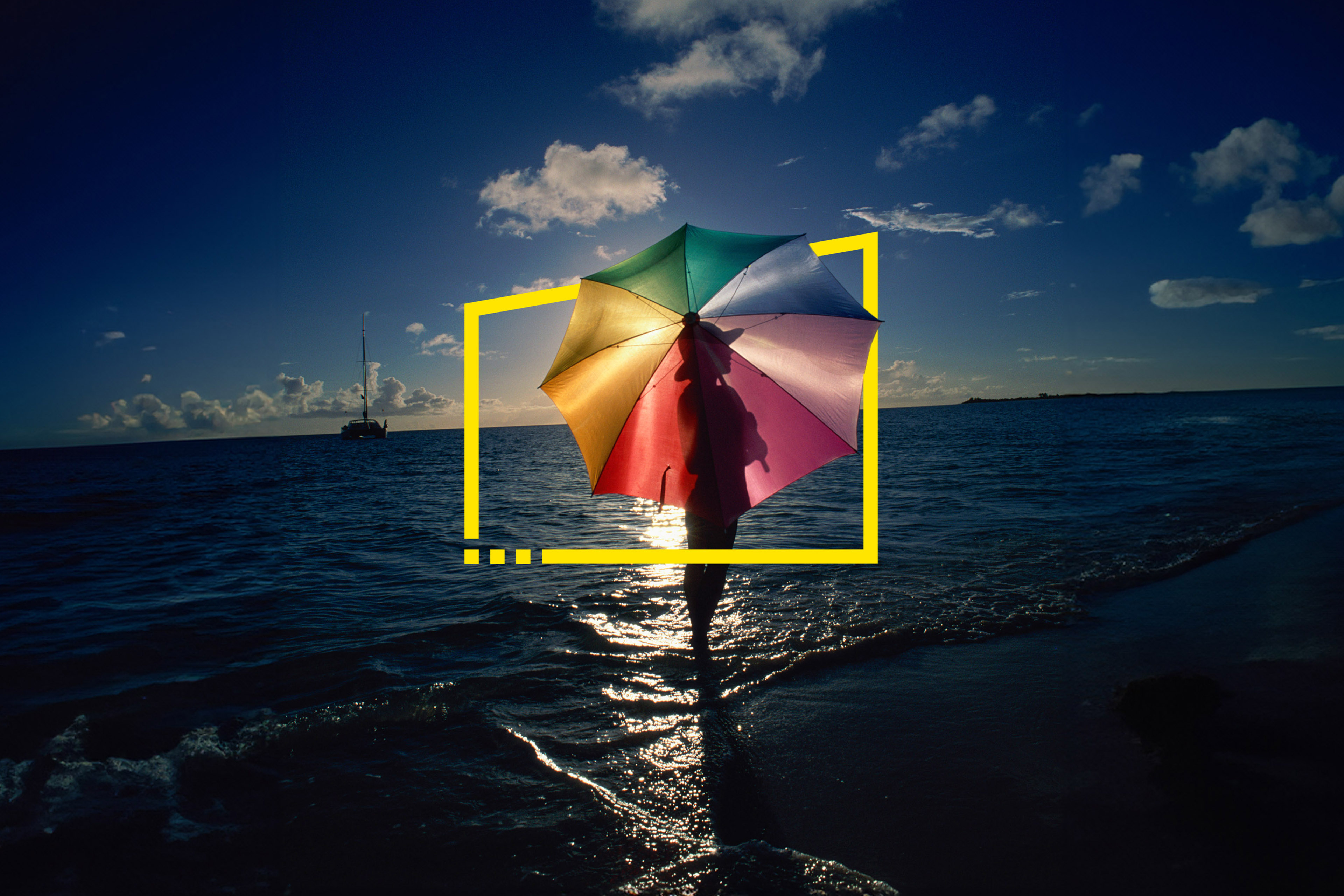 Woman standing on beach with umbrella on caribbean island