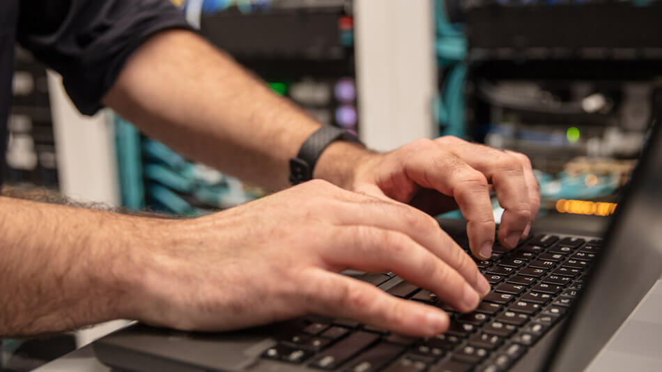 Closeup of a person's hands while typing on a laptop