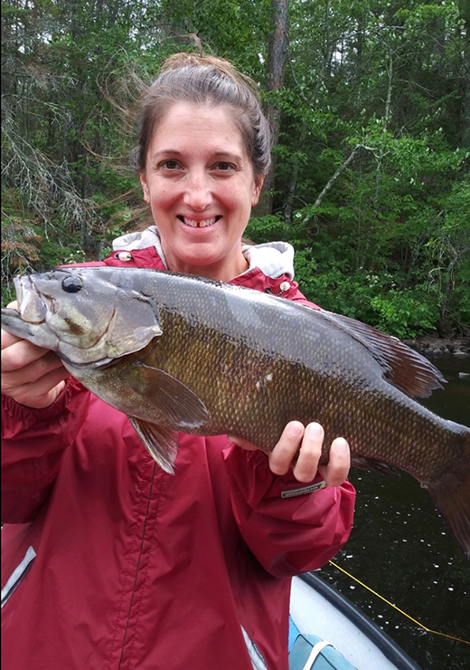 image of woman holding a big smallmouth bass caught near Ely, MN