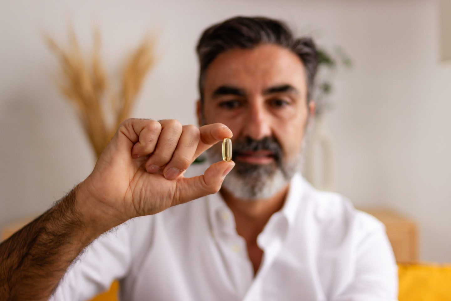 Photo of a man holding a pill