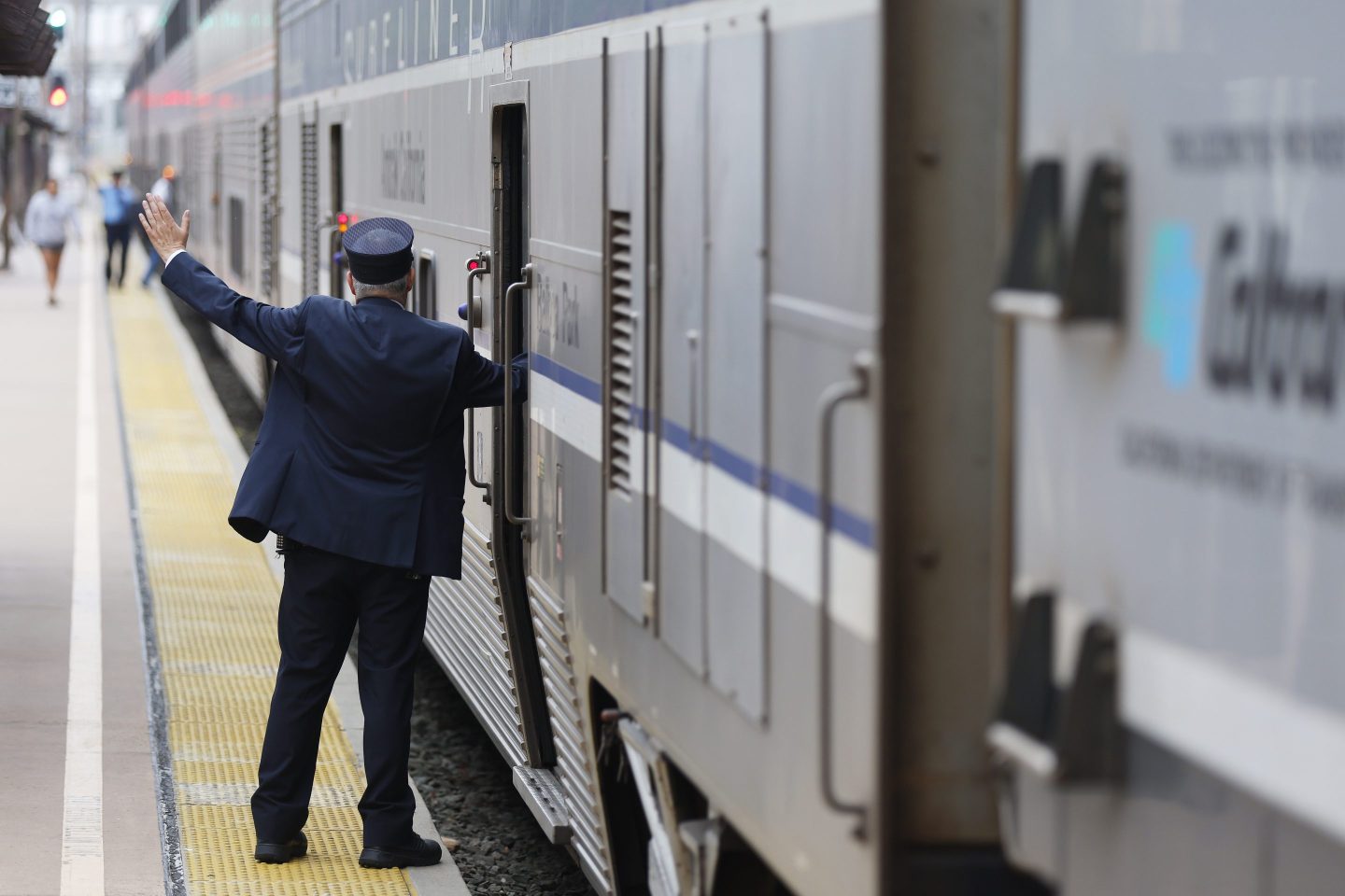 Train conductor waving on platform