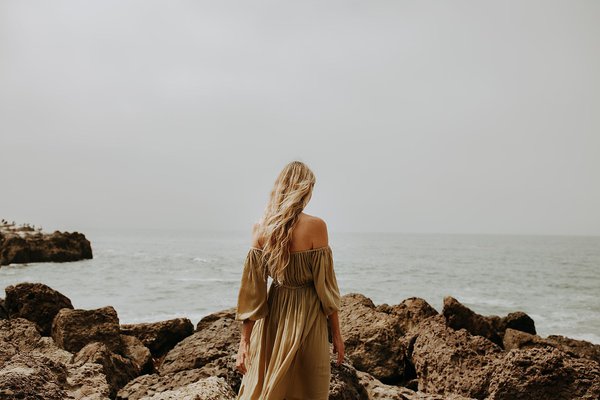 A woman stares out into the ocean