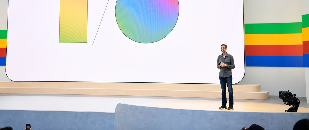 Image of Sundar on stage against backdrop showing the letters I / O with gradient colors filled in.