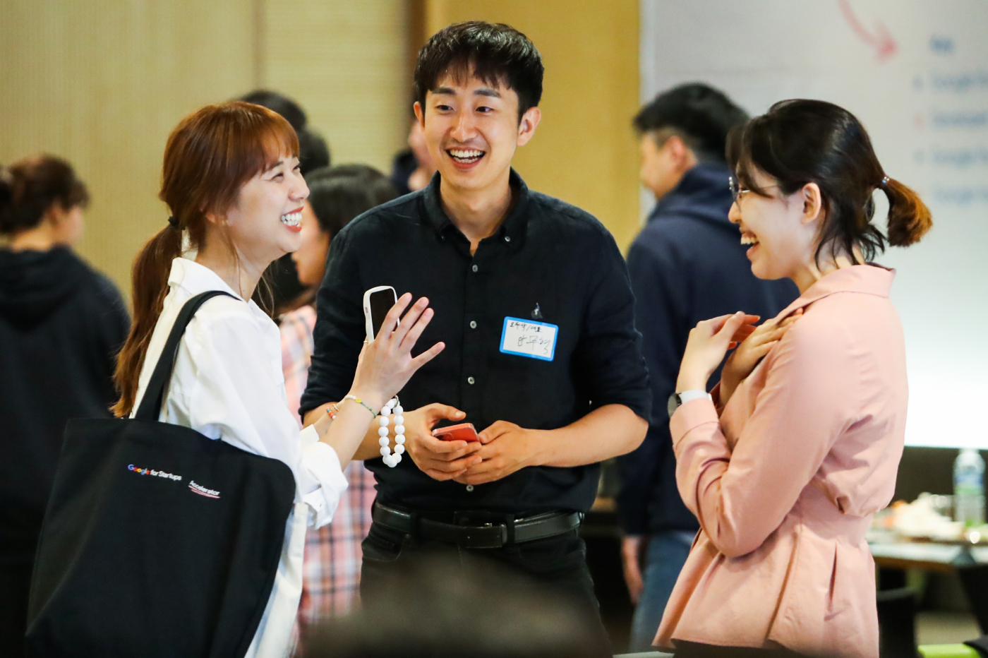 Two women and a men discussing something and laughing.