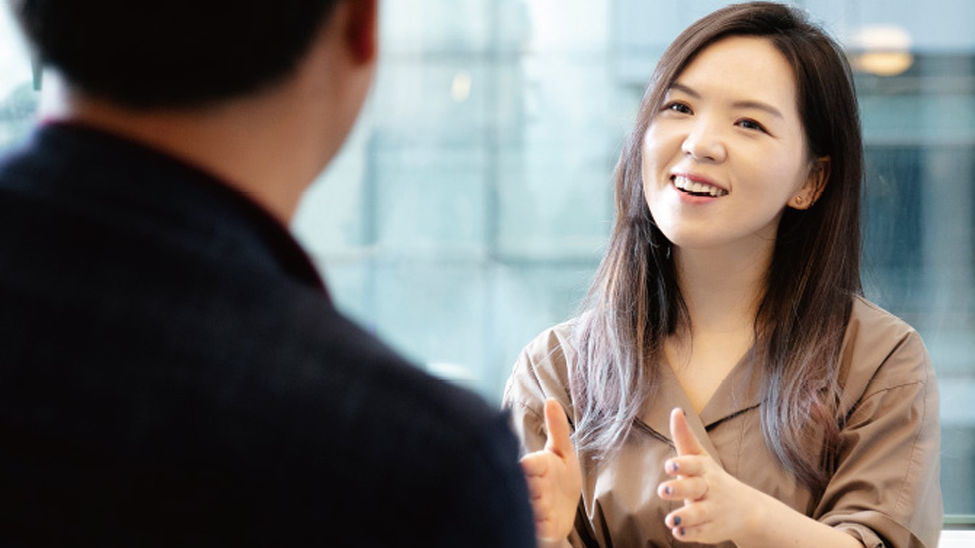 Hanna Kim of Grip smiling while talking to a man