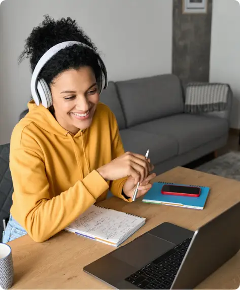 Frau, die am Laptop arbeitet und Kopfhörer trägt