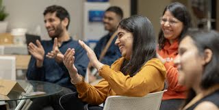 A group of people clapping while laughing