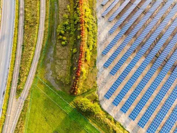 A green field and access road next to a solar farm