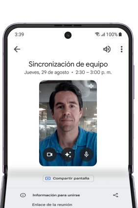 Un teléfono Pixel Fold abierto horizontalmente con una conversación de Google Meet en curso etiquetada como 'reunion de equipo'. La persona al otro lado escucha