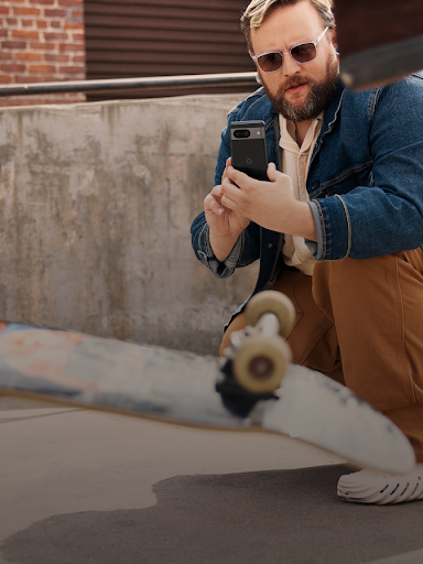 Naka-squat ang user ng Android habang kumukuha ng video ng skateboarder na gumagawa ng trick.