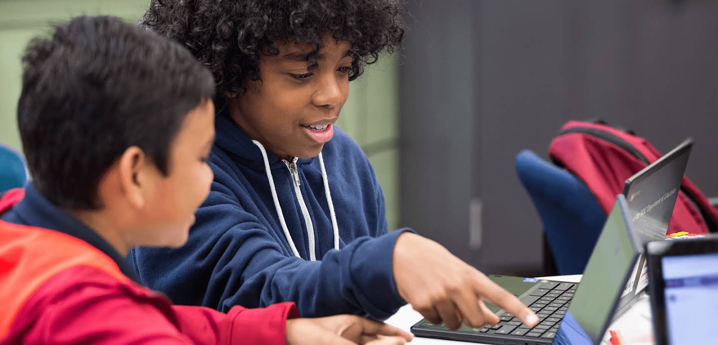 Dos alumnos usando sus Chromebooks en una institución educativa.