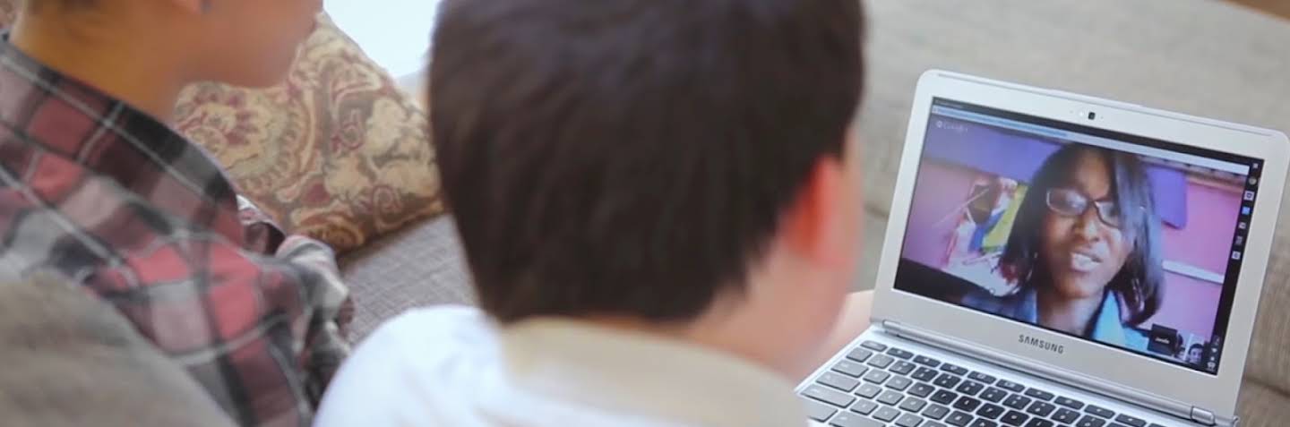 Dwoje dzieci patrzy na ekran laptopa