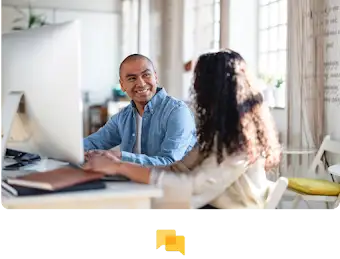 Dos personas trabajan y colaboran frente a un monitor grande.