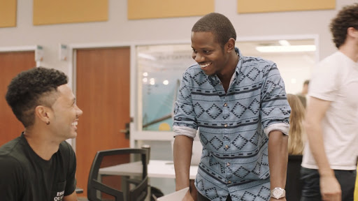 Two men talking to each other, laughing.