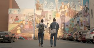 Founders, Justin and Bernard, are walking in front of a mural.