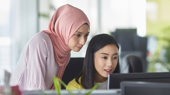 Zwei Frauen, die auf einen Laptop sehen