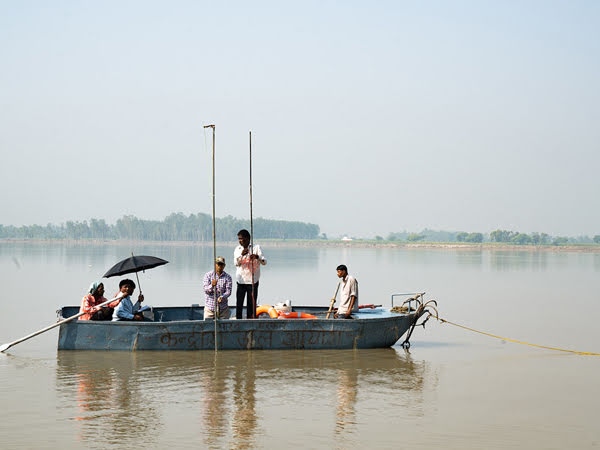 Thuyền viên đang đo độ sâu của sông ở Ấn Độ