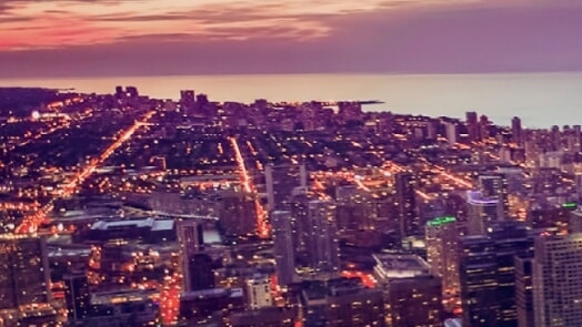 City scene at twilight, with a body of water in the background