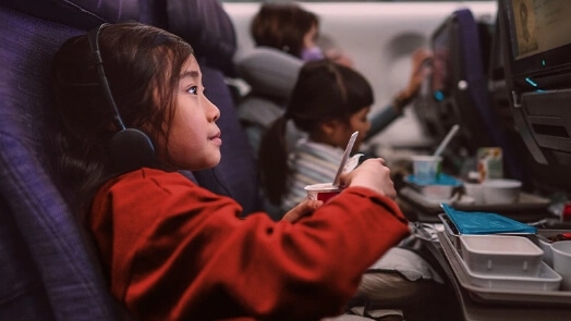 Girl in airplane using edge technology