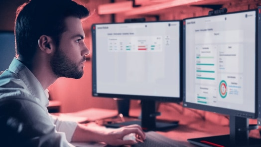 Man at desk with dual monitors