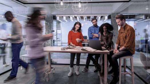 Man and woman in conference room with remote meeting ongoing