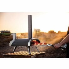 the Ooni Frya 12 pizza oven on a beach during sunset